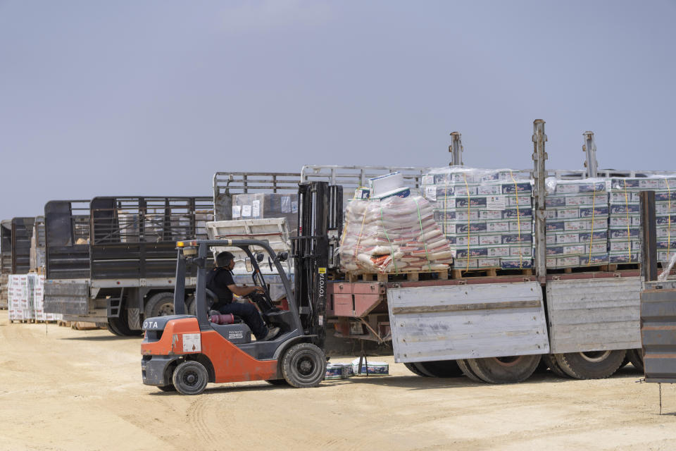 A worker moves a pallet in an inspection area for trucks carrying humanitarian aid supplies bound for the Gaza Strip, on the Palestinian side of the Erez crossing between southern Israel and Gaza, Wednesday, May 1, 2024. (AP Photo/Ohad Zwigenberg)