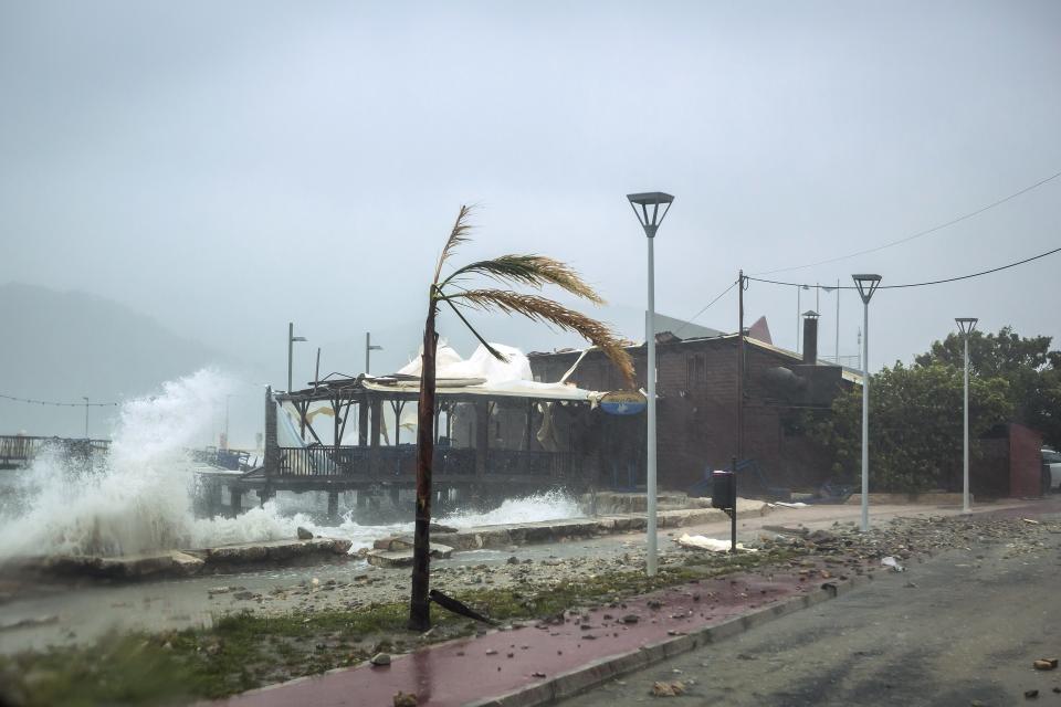 Waves break on a seaside tavern during a storm at the port of Argostoli, on the Ionian island of Kefalonia, western Greece, Friday, Sept. 18, 2020. A powerful tropical-like storm named Ianos battered the western islands of Zakynthos, Kefalonia, and Ithaki overnight, causing flash flooding, property damage, power outages, and road closures mostly from downed trees, police and local authorities said. (AP Photo/Nikiforos Stamenis)