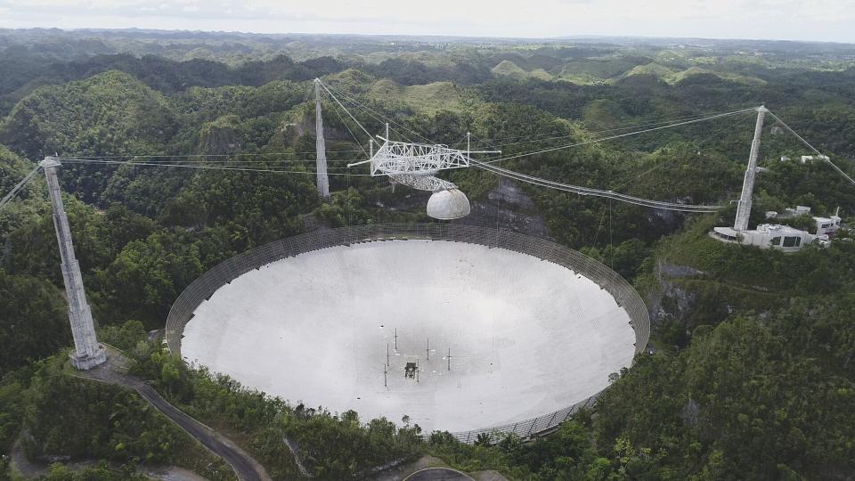 This undated photo provided by researchers in June 2023 shows the Arecibo Telescope in Puerto Rico. This and several other telescopes around the world were used to observe the slow gravitational waves — faint ripples made by massive black holes — that are constantly stretching and squeezing everything in the universe ever so slightly, described in a report released on Wednesday, June 28, 2023. (NAIC via AP)