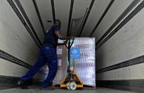 A man loads healthcare material to be sent to Afghanistan, at a UNHCR warehouse, part of the International Humanitarian City in Dubai, United Arab Emirates, Monday, June 27, 2022. (AP Photo/Kamran Jebreili)