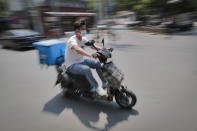 A food delivery worker wearing a protective face mask to help curb the spread of the new coronavirus rides on a street in Beijing, Sunday, June 21, 2020. According to state media reports, nearly one hundred thousand delivery workers have to accept the nucleic acid testing, a countermeasure to prevent the spread of the virus in the capital city. (AP Photo/Andy Wong)