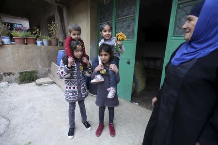 A Lebanese woman stands next to Lebanese children near a cannabis workshop in the Bekaa valley, Lebanon November 1, 2015. REUTERS/Alia Haju