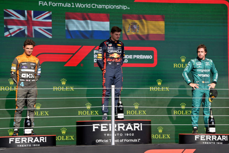 (L t R) McLaren's British driver Lando Norris, Red Bull Racing's Dutch driver Max Verstappen and Aston Martin's Spanish driver Fernando Alonso stand on the podium after the Formula One Brazil Grand Prix at the Autodromo Jose Carlos Pace racetrack, also known as Interlagos, in Sao Paulo, Brazil, on November 5, 2023. Verstappen won the race, Norris finished second while Alonso placed third. (Photo by NELSON ALMEIDA / AFP) (Photo by NELSON ALMEIDA/AFP via Getty Images)