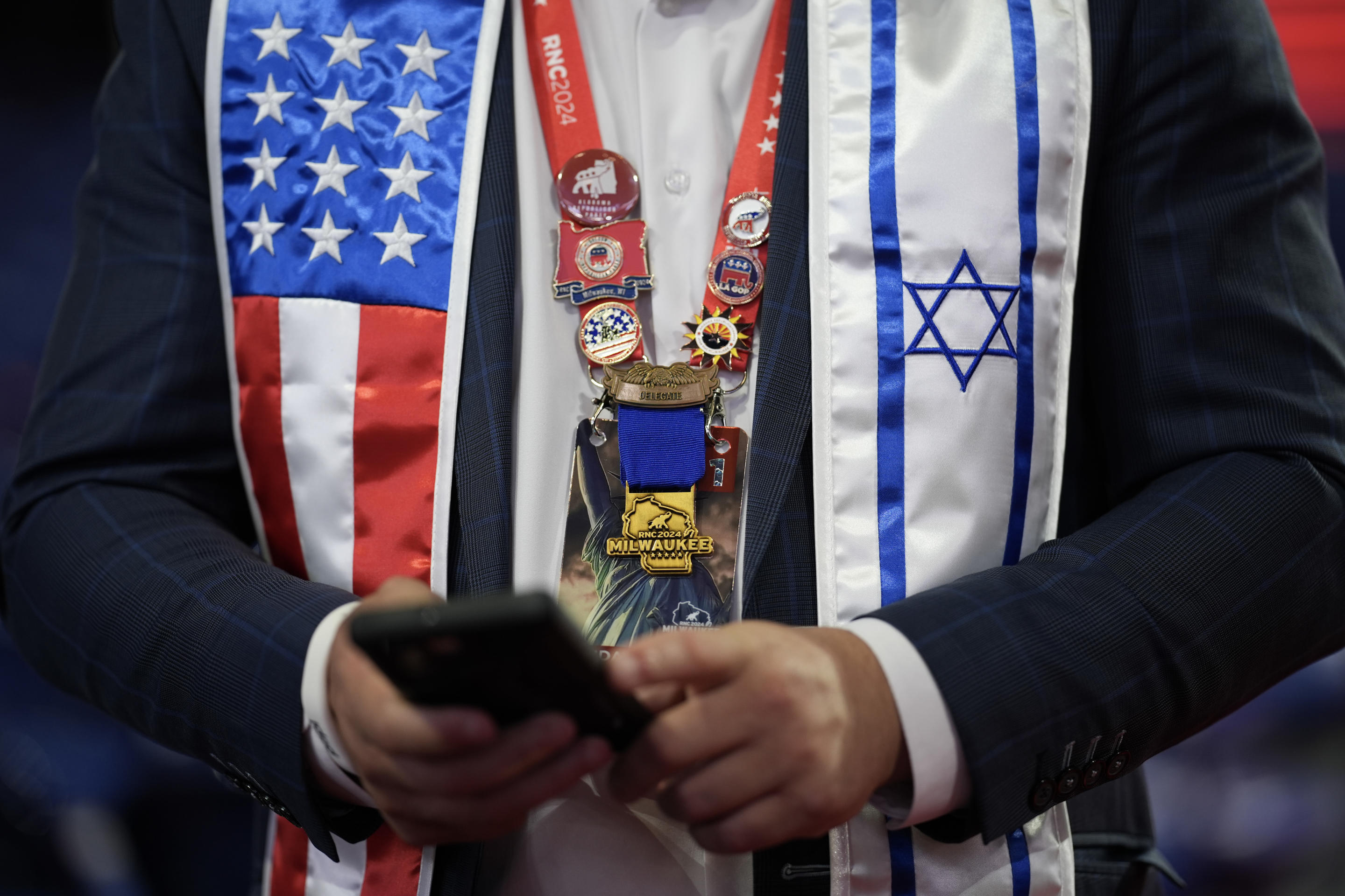 An attendee checks their phone before the start of the convention. (Andrew Harnik/Getty Images)