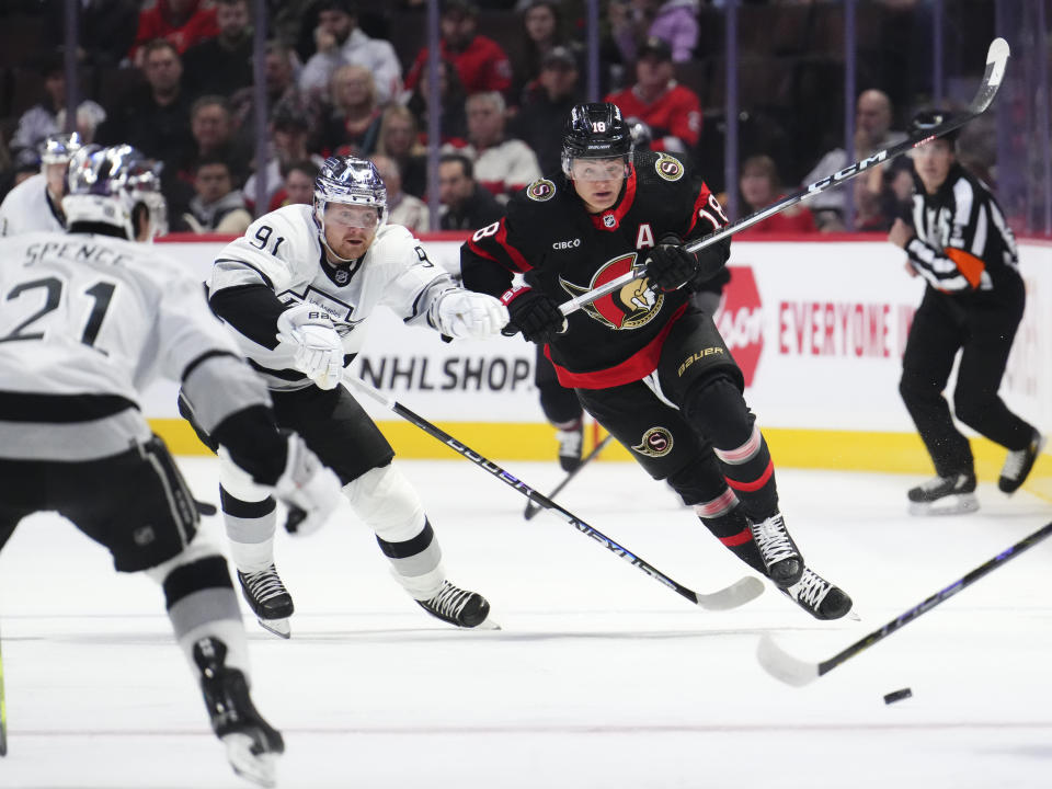 Ottawa Senators center Tim Stutzle (18) skates around Los Angeles Kings right wing Carl Grundstrom (91) as he chases the puck during the first period of an NHL hockey game Thursday, Nov. 2, 2023, in Ottawa, Ontario. (Sean Kilpatrick/The Canadian Press via AP)
