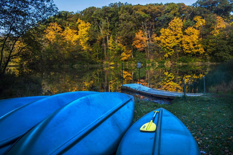 In this 2015 file photo, sunlight strikes leaves turning on the bank of the lake at Camp Wokanda.