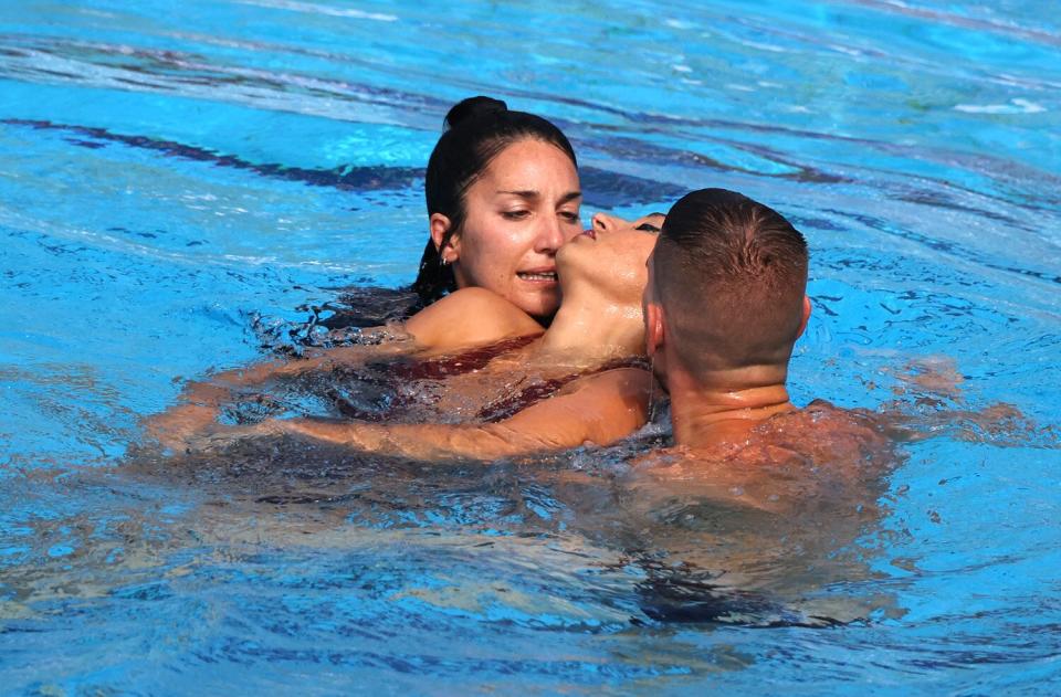 A member of Team USA (L) recovers USA's Anita Alvarez (C), from the bottom of the pool during an incident in the women's solo free artistic swimming finals, during the Budapest 2022 World Aquatics Championships