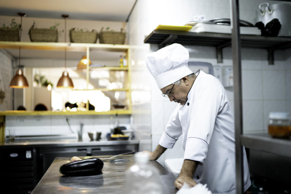 A chef looks defeated, standing at his station