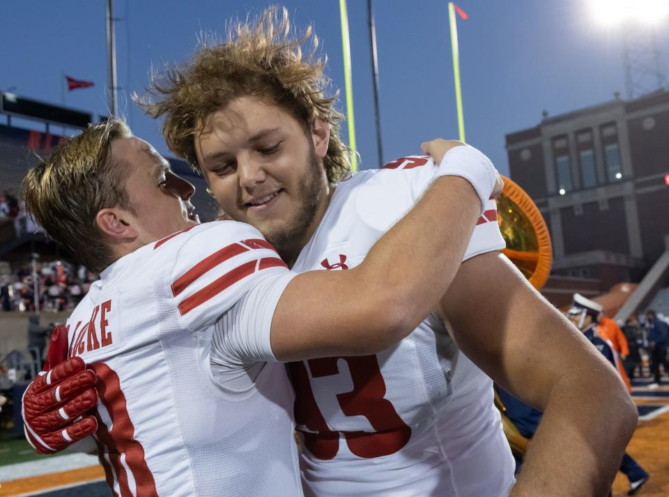 Braedyn Locke of the Wisconsin Badgers celebrates with Nolan Rucci following the game against the Illinois Fighting Illini at Memorial Stadium on Oct. 21, 2023, in Champaign, Illinois.