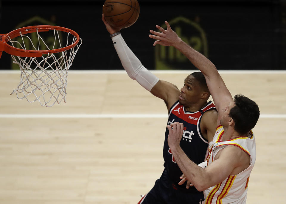 Washington Wizards' Russell Westbrook, left, lays up a shot past Atlanta Hawks' Danilo Gallinari in the second half of an NBA basketball game Monday, May 10, 2021, in Atlanta. (AP Photo/Ben Margot)