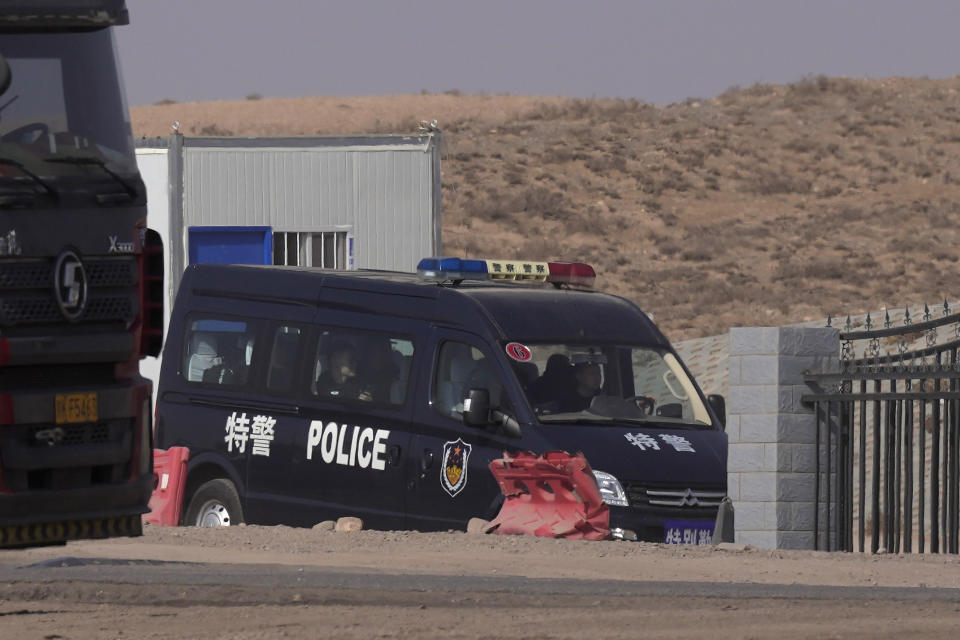 A police van drives through a checkpoint along a road in Qingtongxia on northern China's Ningxia Hui Autonomous Region leading to the site of a collapsed open pit mine in Alxa League in northern China's Inner Mongolia Autonomous Region, Friday, Feb. 24, 2023. Rescuers have changed their approach to search for dozens of people missing from a coal mine collapse in northern China to avoid further landslides, state broadcaster CCTV reported Friday. (AP Photo/Ng Han Guan)