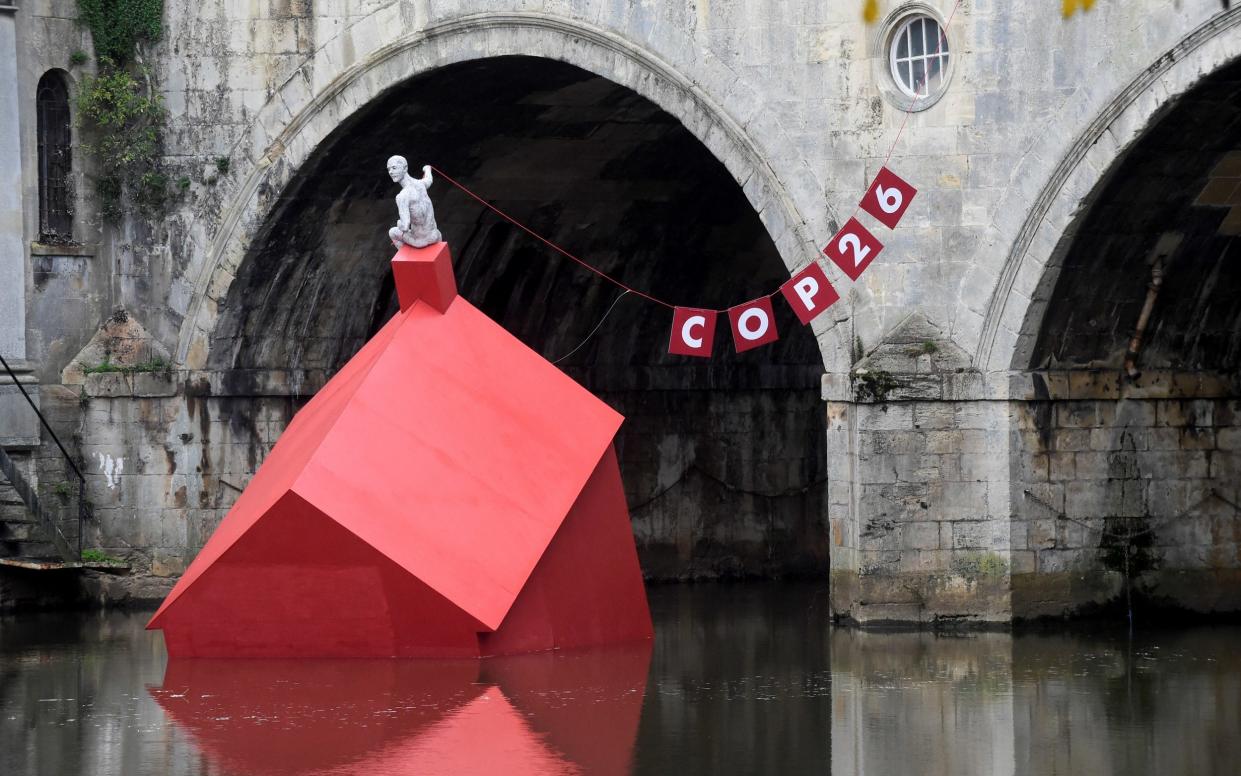 An installation of a 'Sinking House' is partly submerged to highlight climate change ahead of COP26, in Bath - REBECCA NADEN /REUTERS 