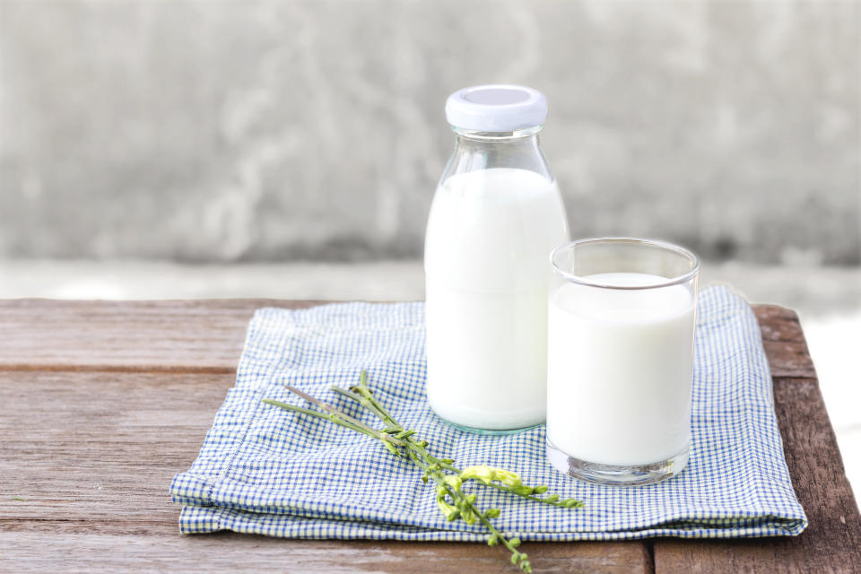 glass of milk and bottle of milk on the wood table. with copy space for text.