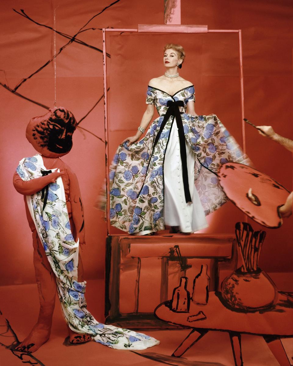 “The Flower Image: Further Analyzed. A pretty picture of Infanta-ilism here—a dress of poppy cotton organdie puffing wide over a taffeta underskirt. Designed by Pierre Balmain–New York. (The setting [by Marcel Vertès]: the studio of a mythical and most contrariwise painter—out of a surrealistic still-life, he creates a portrait of alive and classic beauty.)”