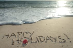 happy holidays  written in sand