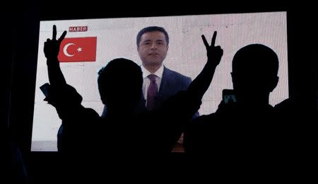 Supporters of Turkey's main pro-Kurdish Peoples' Democratic Party (HDP) watch the jailed former leader and presidential candidate Selahattin Demirtas as his first television appearance in over a year and a half is seen live on a huge screen during campaign event in Istanbul, Turkey, June 17, 2018. REUTERS/Huseyin Aldemir/Files