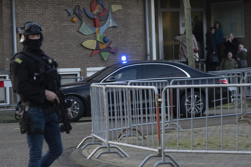 Masked and armed Dutch police guard a transport of some of the suspects who arrived a the high security court building where the trial opened in Amsterdam, Netherlands, Tuesday, Jan. 23, 2024, for suspects in the slaying of campaigning Dutch journalist Peter R. De Vries. Defendants include the suspected shooter, getaway driver and alleged organizers of the July 2021 shooting in the Dutch capital. (AP Photo/Peter Dejong)