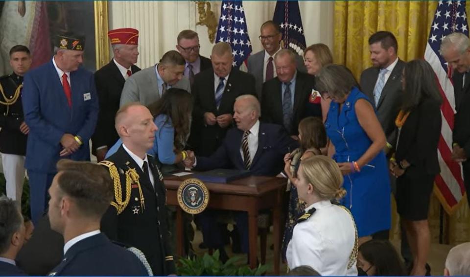 President Joe Biden speaks to people Wednesday during a signing ceremony in the White House East Room for the PACT Act, which provides additional benefits to veterans who were exposed to toxic burn pits in war zones.