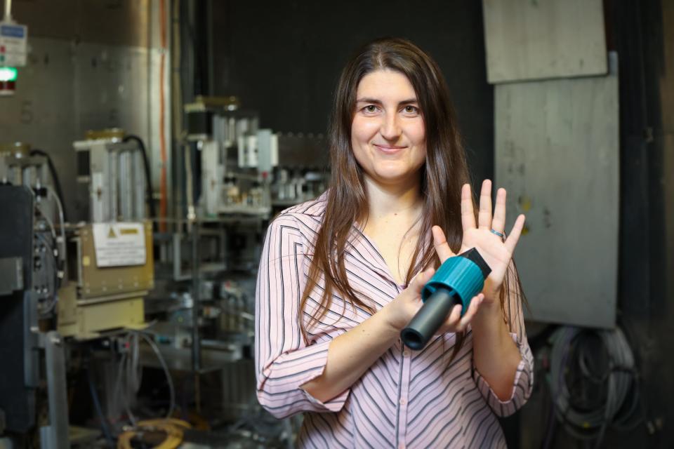 Oak Ridge National Laboratory’s Leah Broussard shows a neutron-absorbing "wall" that stops all neutrons but in theory would allow hypothetical mirror neutrons to pass through. Credit: Genevieve Martin/ORNL, U.S. Dept. of Energy