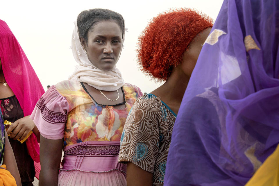 In this July 25, 2019 photo, Ethiopian Tigray migrants stand in lines as they are counted by smugglers after arriving to the coastal village of Ras al-Ara from Djibouti, in Lahj, Yemen. According to the U.N.'s International Organization for Migration the number of women making the trip jumped from nearly 15,000 in 2018 to more than 22,000 in 2019. The number of girls had an enormous increase, quadrupling from 2,075 to 8,360. Despite the many risks – smugglers' exploitation, hunger, drowning – they are undaunted. (AP Photo/Nariman El-Mofty)