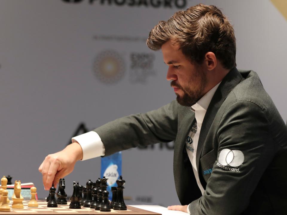 Norway's World Chess Champion Magnus Carlsen, makes a move in Game 5 against Ian Nepomniachtchi of Russia, during the FIDE World Championship at the Dubai Expo on Dec. 1, 2021.