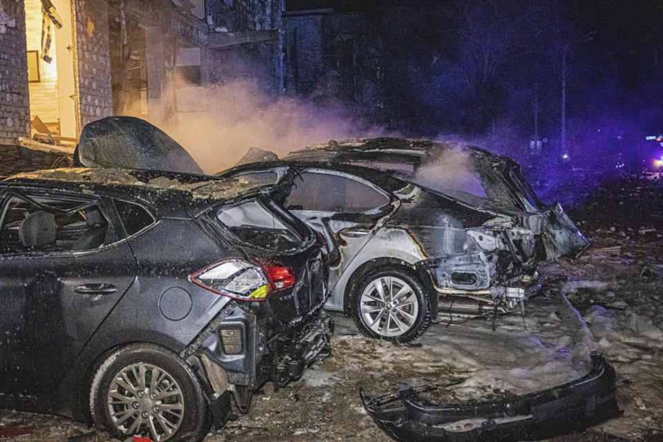In this photo provided by the Ukrainian Emergency Service, cars burn after a Russian rockets attack that hit a hotel in Kharkiv, Ukraine, late Wednesday, Jan. 10, 2024. (Ukrainian Emergency Service via AP)