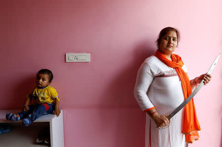 Hindu Yuva Vahini member Kusum Singh, 30, poses inside the vigilante group's office in the city of Unnao, India, April 5, 2017. P REUTERS/Cathal McNaughton