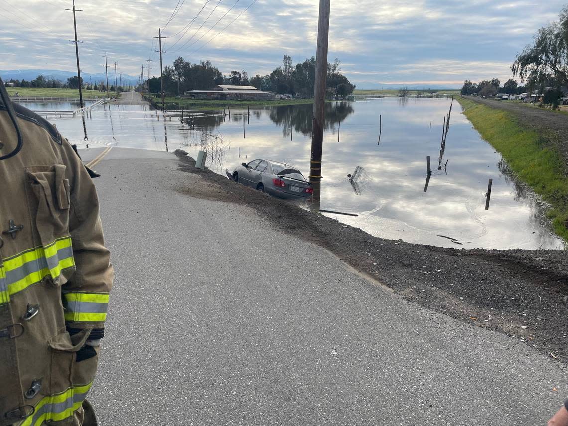 A car is shown partially submerged on an unidentified road in this image shared by Fresno County on social media Friday morning, March 10, 2023.