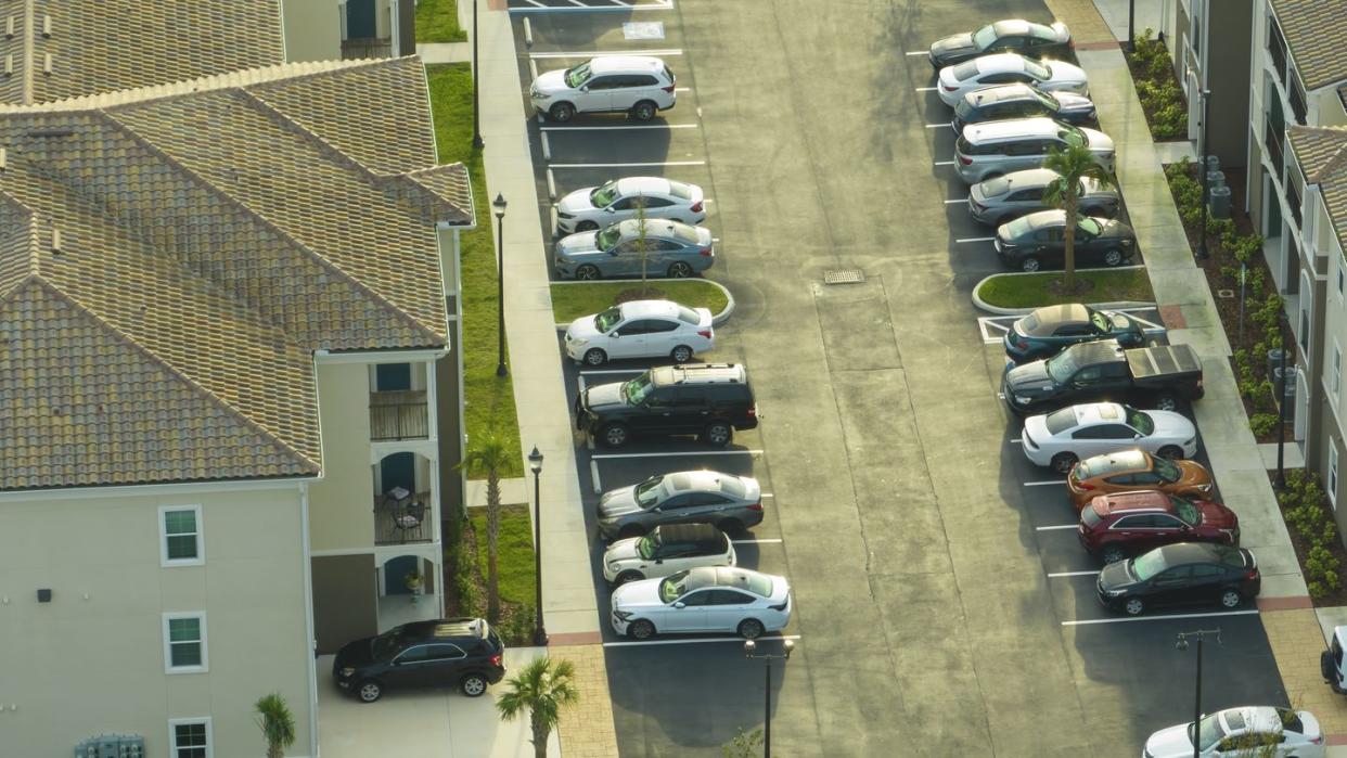 cars parked on parking place of new apartment condos in florida suburban area family housing in quiet neighborhood real estate development in american suburbs