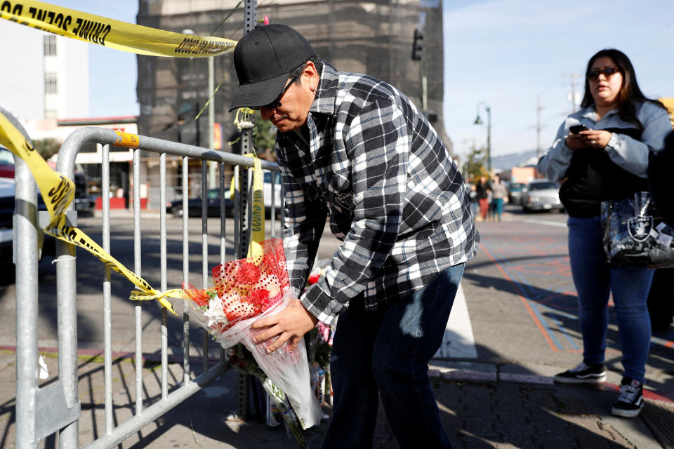 Joel Cruz, of Milpitas, places flowers at a makeshift memorial near the scene of a fire in the Fruitvale district of Oakland, California, U.S. December 4, 2016. REUTERS/Stephen Lam