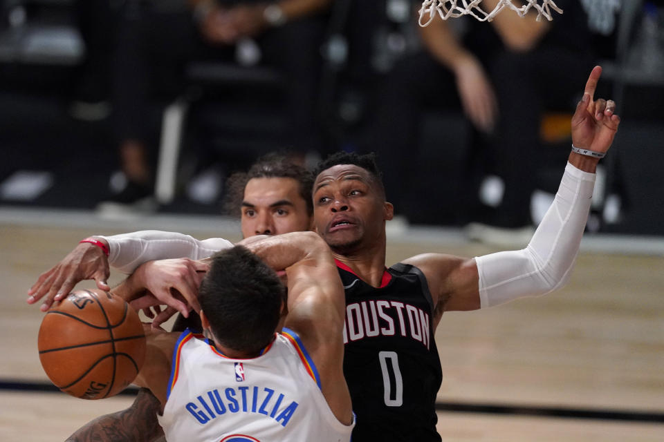 Oklahoma City Thunder's Danilo Gallinari, front, loses control of the ball to Houston Rockets' Russell Westbrook (0), right, as Steven Adams, rear, looks on during the second half of an NBA first-round playoff basketball game in Lake Buena Vista, Fla., Wednesday, Sept. 2, 2020. (AP Photo/Mark J. Terrill)