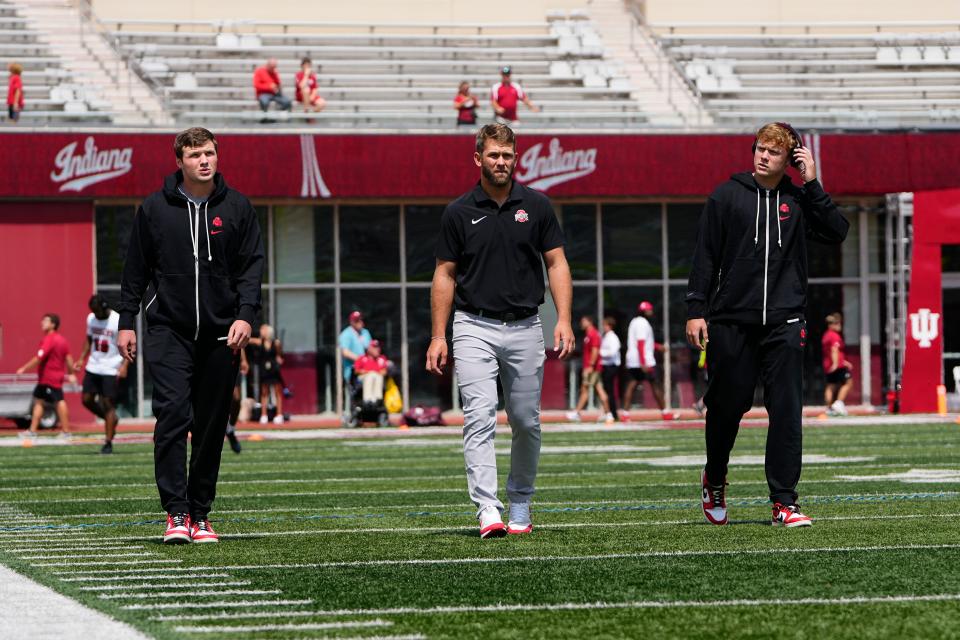 Sep 2, 2023; Bloomington, Indiana, USA; Ohio State Buckeyes quarterbacks Devin Brown (33) and Kyle McCord (6) walk out onto the field with coach Corey Dennis after arriving at Indiana University Memorial Stadium prior to the NCAA football game.