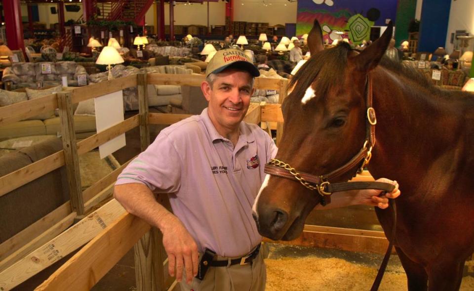 Jim McIngvale stands with Some Actor, one of his Thoroughbreds, in a makeshift pen in the showroom at Gallery Furniture in Houston in 2000. Some Actor was on display in the store while recovering from a hoof injury.