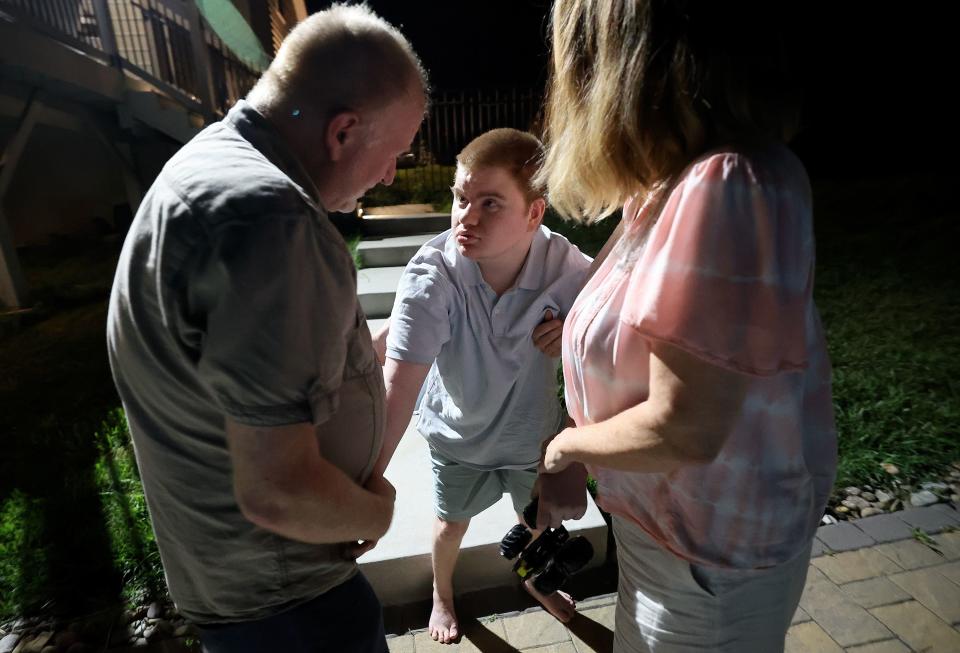 Glenn Maughan and Annette Maughan help support their son Glenn Maughan, nicknamed Bug, as Bug recovers from a tonic seizure outside of their home in Manchester, Md., on Saturday, July 8, 2023. Bug, age 20, has KBG syndrome. | Kristin Murphy, Deseret News