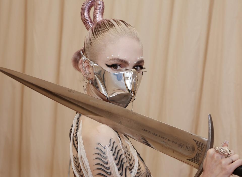 Grimes holds the sword, leaning it on her shoulder