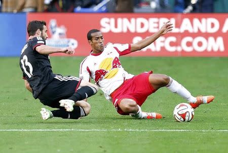 Nov 8, 2014; Washington, DC, USA; New York Red Bulls defender Roy Miller (7) and D.C. United midfielder/forward Chris Pontius (13) slide for the ball in the first half of leg 2 of the Eastern Conference semifinals in the 2014 MLS Cup Playoffs at Robert F. Kennedy Memorial Stadium. Mandatory Credit: Geoff Burke-USA TODAY Sports