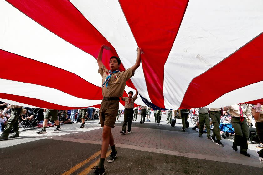 Los Angeles, CA - Boys Scouts carry a huge American flag down Main Street during the Huntington Beach Independence Day Parade on July 4, 2023. Thousands of people gathered in the Orange County coastal community for the annual ecvent. July 04: in Los Angeles on Tuesday, July 4, 2023 in Los Angeles, CA. (Luis Sinco / Los Angeles Times)