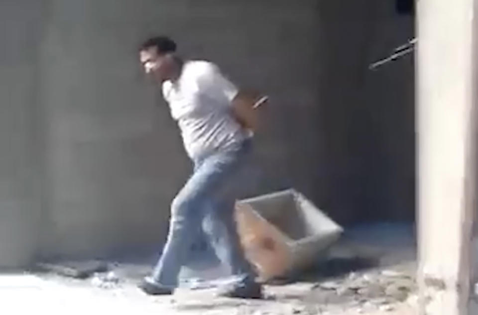 This frame grab from a 2013 video, shows Syrian Wassim Siyam blindfolded being forced to run into a large pit full of bodies all shot dead by Syrian soldiers, in the Tadamon neighborhood of Damascus, Syria. For many years, the Siyam family believed their adult son was being held at a government prison after he went missing at a checkpoint nearly a decade ago. Last month, the hope that he would one day return came to an abrupt end after a newly released video taken in 2013 showed him among dozens of blindfolded young men who were thrown into a large pit and shot dead by Syrian agents, who then set the bodies on fire. (AP Photo)