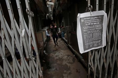 A poster is hanged at the entrance of a closed garments market during a protest against the implementation of the goods and services tax (GST) on textiles, in the old quarters of Delhi, June 29, 2017. REUTERS/Adnan Abidi