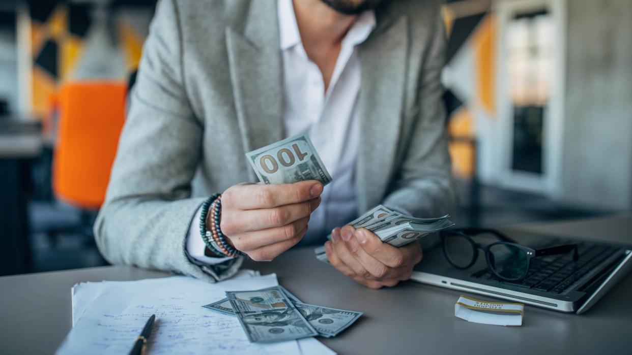 Handsome businessman working in the office and counting money.