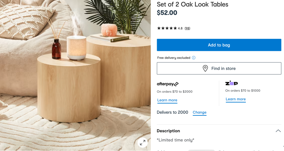 Set of two oak look tables, $52 from Kmart, shown in a loungeroom setting, with cream carpet and cream beanbags and cushion, potted plant, candles and fragrance sticks.