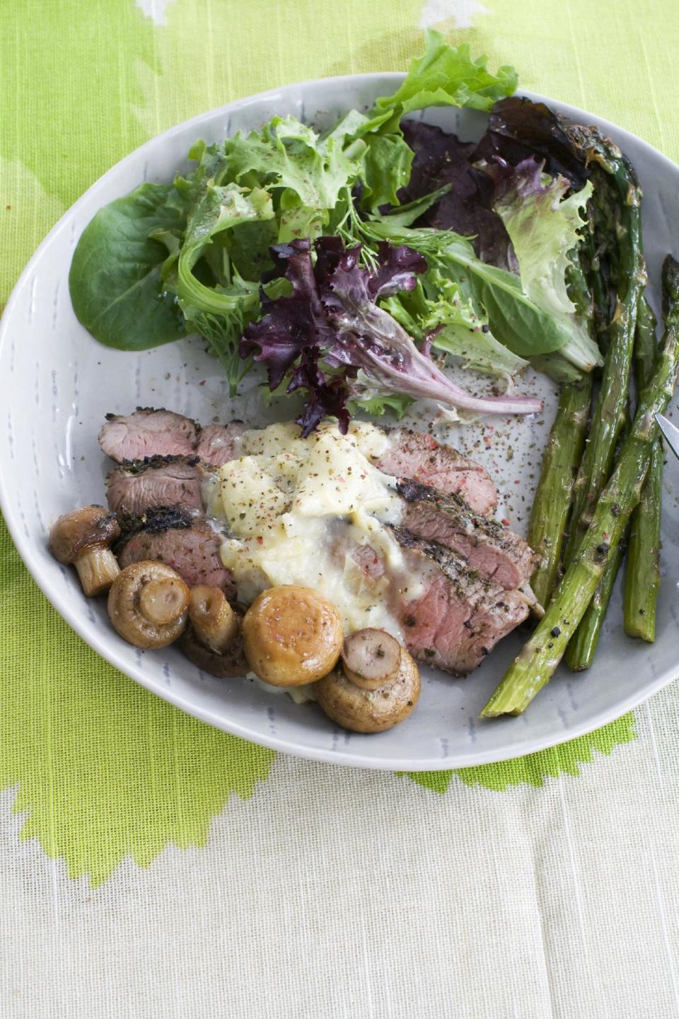 In this image taken on March 11, 2013, grilled lamb steaks with artichoke lemon sauce are shown served on a plate in Concord, N.H. (AP Photo/Matthew Mead)