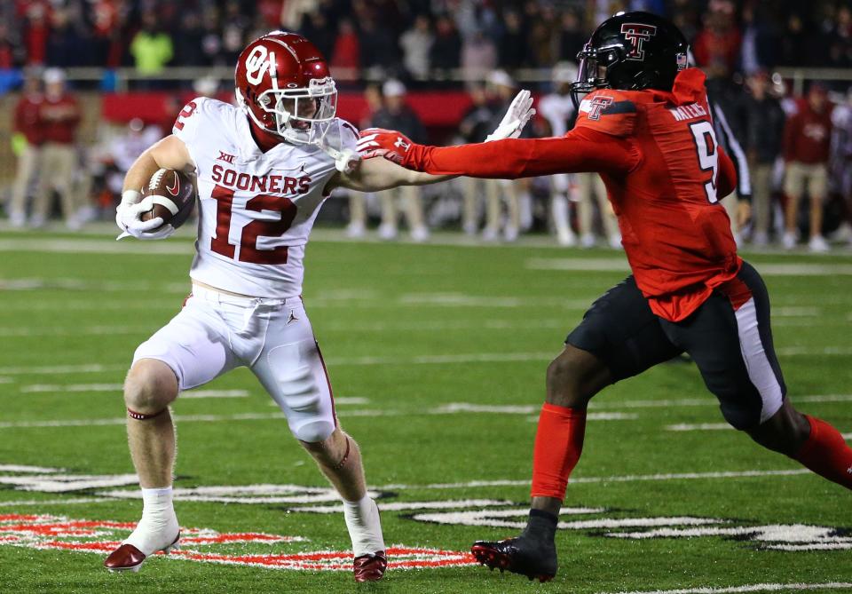 Oklahoma Sooners wide receiver Drake Stoops (12) stiff arms Texas Tech Red Raiders defensive back Marquis Waters (9) in the first half at Jones AT&T Stadium and Cody Campbell Field.