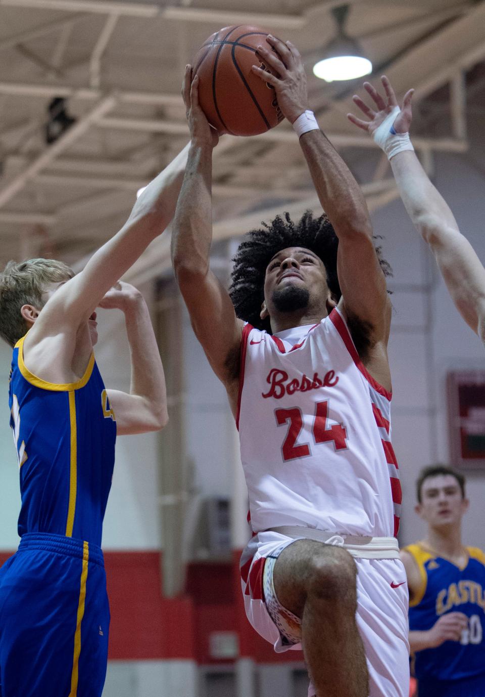 Bosse's Chris Glover II (24) drives to the basket past Castle's Xander Niehaus (12) during their game at Bosse High School Thursday night, Feb. 2, 2023.