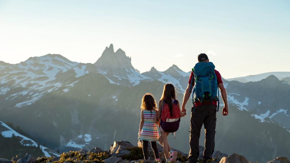 Father with young daughters exploring nature