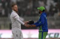 England's Ben Stokes, left, shakes hand with his Pakistani counterpart Babar Azam after winning the first test cricket match against Pakistan, in Rawalpindi, Pakistan, Monday, Dec. 5, 2022. (AP Photo/Anjum Naveed)