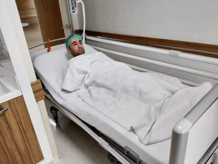 Ibrahim Alğan is laying in a hospital bed before his surgery.