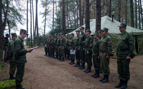 Belarus' Col.Alexander Prokopenko, left, reads his order to start the drills at a training ground - Credit: Vayar m/AP