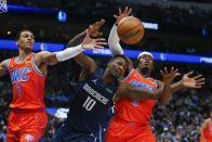 Dallas Mavericks forward Dorian Finney-Smith (10) battles Oklahoma City Thunder forwards Darius Bazley (7) and Luguentz Dort (5) for a rebound during the first half of an NBA basketball game, Monday, Jan. 17, 2022, in Dallas. (AP Photo/Brandon Wade)