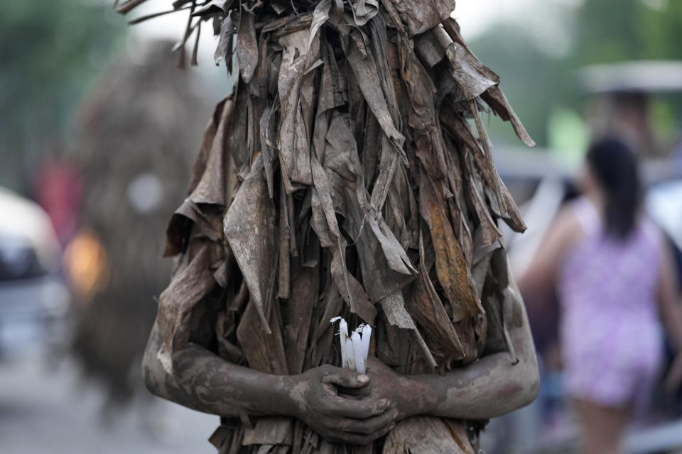 A devout Catholic walks towards the church of Saint John the Baptist during the mud festival at Bibiclat, Nueva Ecija province, northern Philippines, Monday, June 24, 2024. (AP Photo/Aaron Favila)